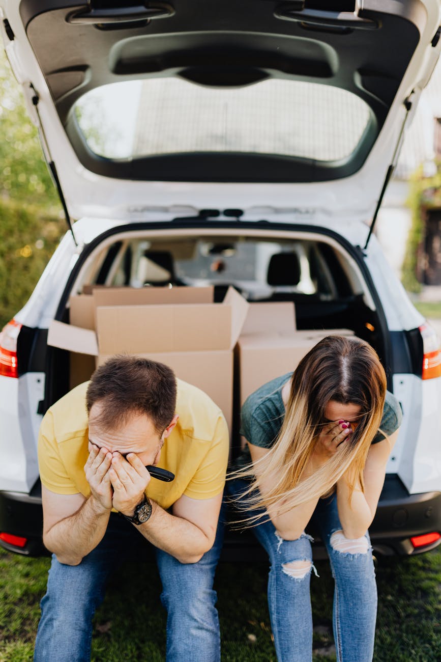 台灣房貸為何難貸? tired couple sitting on car luggage boot