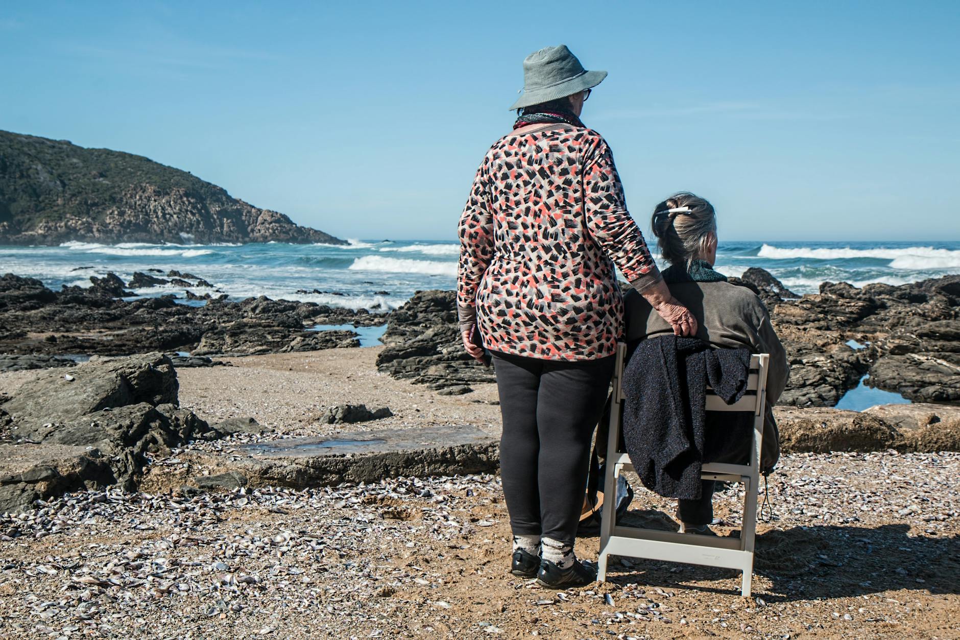 高齡友善住宅設計與改造專業報告 woman standing beside woman on white wooden chair facing body of water
