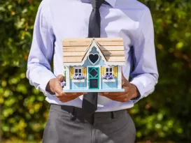 person holding a miniature house