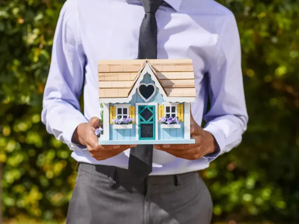 person holding a miniature house