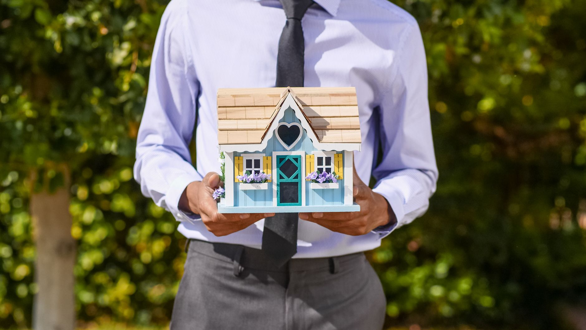 person holding a miniature house